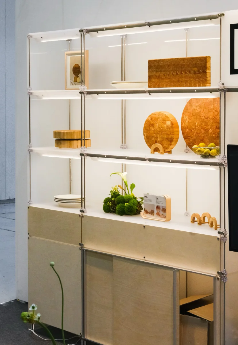 Modular aluminum display shelves presenting wooden objects and greenery